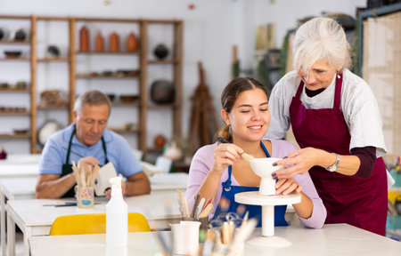 Potter woman in workshop gives modeling lessonの写真素材