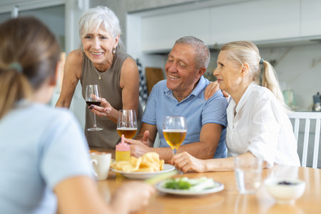 Elderly people drinking and chatting at tableの写真素材