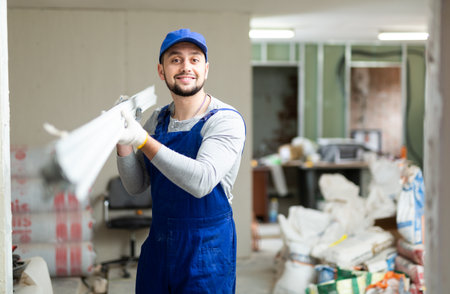 Portrait of a builder in the process of working on a construction siteの写真素材