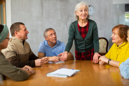 Mature female professor giving lecture to elderly studentsの写真素材