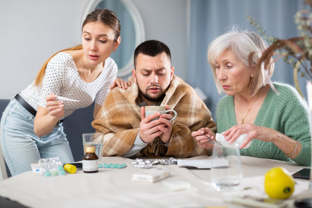 Wife and mother-in-law taking care of ill manの写真素材