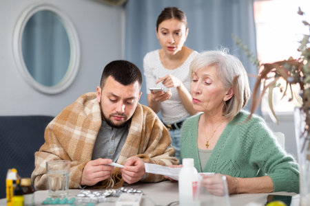 Family taking care of sick man at homeの写真素材
