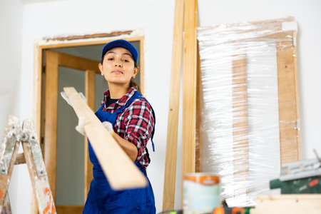 Female worker installing door jambs in room being renovatedの写真素材