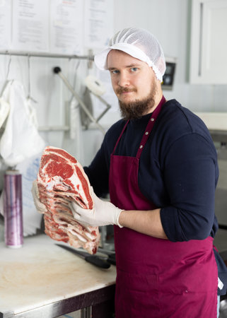 Butcher is demonstraiting meat to clients indoorsの写真素材