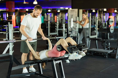Trainer trains woman with exercise machine