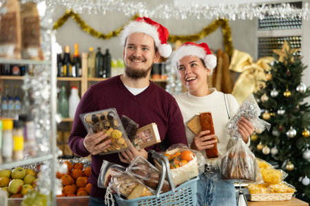 Preparing for Christmas celebration - happy family buys nougat, panettone, marzipan, panelletsの写真素材