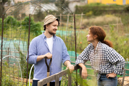 European woman in checkered shirt, chatting with man neighborの写真素材