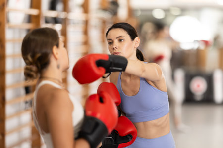Women fight with hands, using all strength, courage during boxing lessonの写真素材