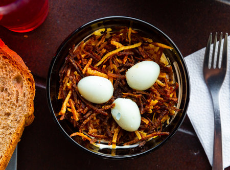 Salad "Capercaillies Nest" with boiled eggs and fried potatoesの写真素材