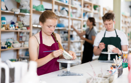 Teenagers are interested in making dishes from clay in pottery workshop