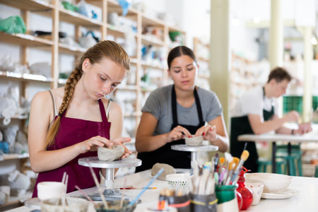 Teenage girl sculpts ceramic product in ceramic workshopの写真素材
