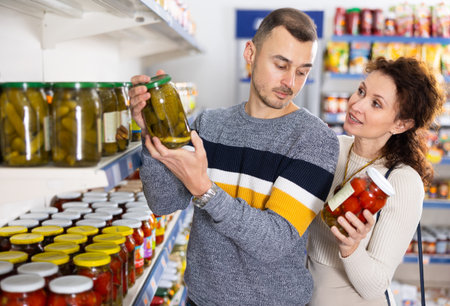 Portrait of an couple buying a salted tomatoes and cucumbers at grocery store