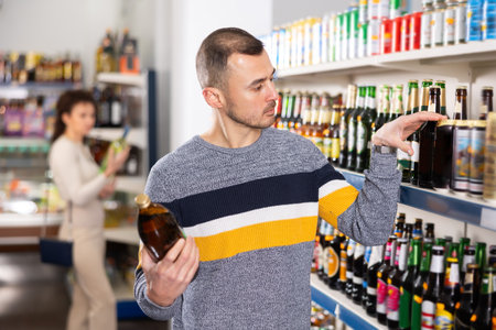 Adult man choosing beer in storeの写真素材