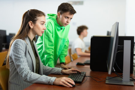 Female teacher explaining task solution to young boyの写真素材