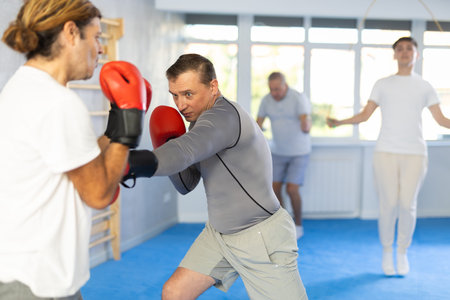 Boxing fight of two athletic men in gym