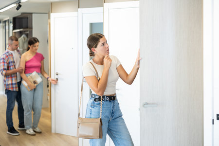 Young woman choosing door in hardware storeの写真素材