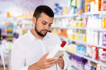 Bearded man choosing cosmetic product at pharmacyの写真素材