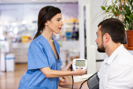 Pharmacist measures arterial blood pressure with a tonometer in man