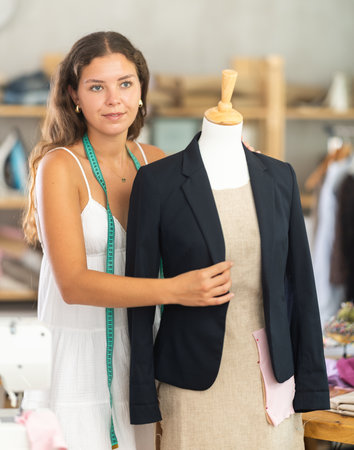 Female tailor fitting black blazer on mannequinの写真素材