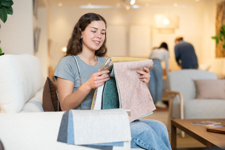 Portrait of woman choosing upholstery fabric in furniture salonの写真素材