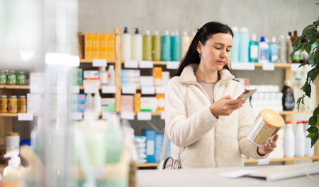 Middle-aged woman customer choosing baby food in drugstoreの写真素材