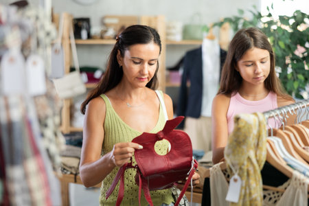 Middle-aged woman choosing handbag in clothing storeの写真素材