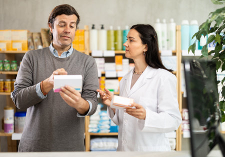 Man chooses packages with pills against the background of pharmacistの写真素材