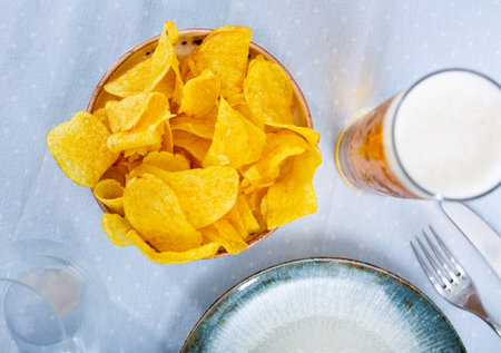 Potato chips and beer served on tableの写真素材