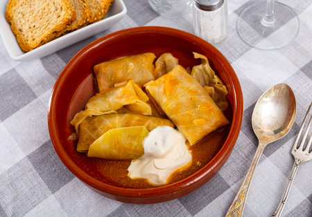 Cabbage rolls in cabbage leaves with sour cream, dish of Eastern European cuisine closeup