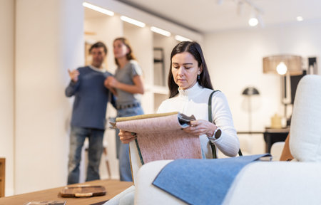 European woman looks at upholstery fabric in a storeの写真素材