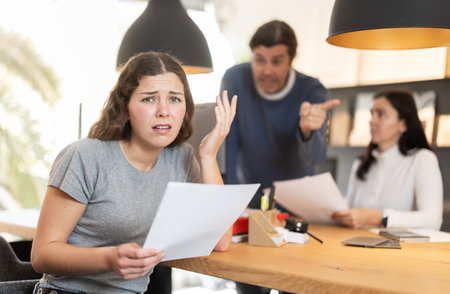 Upset girl argues with store managers, unhappy with terms of purchase agreement in furniture storeの写真素材