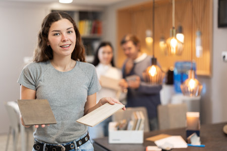 Female buyer with samples of material chooses kitchen set in furniture storeの写真素材
