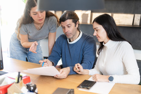 Married couple discusses the terms of purchasing a new kitchen set with furniture store managerの写真素材