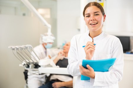Young woman nurse with paper is standing in dental office, clinicの写真素材