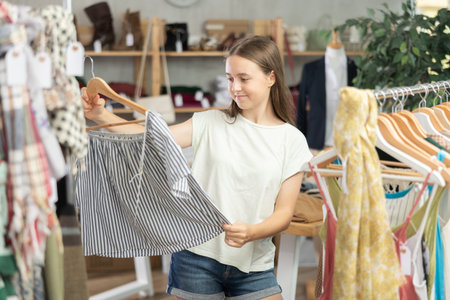 Teenage girl choosing top in clothing storeの写真素材