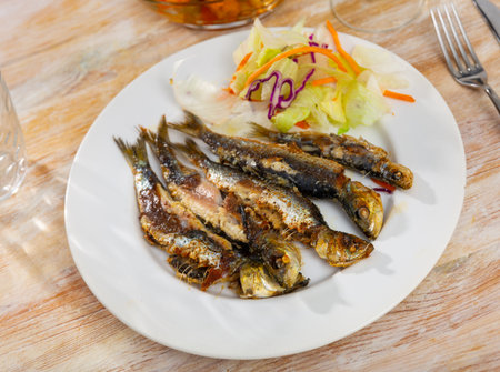 Grilled sardines served with fresh vegetable saladの写真素材