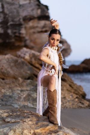 Girl on seashore in revealing carnival costume and bootsの写真素材