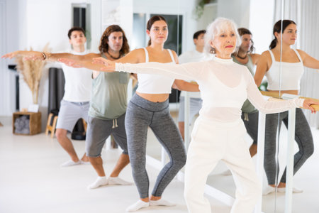 Group of different people doing ballet at barreの写真素材