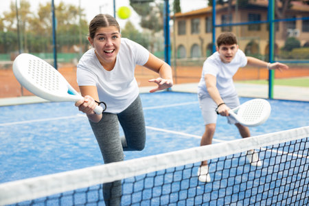 Young sporty couple playing paddle tennis outdoorsの写真素材