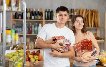 Young couple selecting snacks in grocery store for gatheringの写真素材