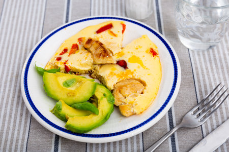 Chicken omelette served with sliced avocadoの写真素材