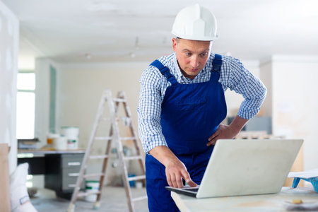 Man builder using laptop in construction siteの写真素材