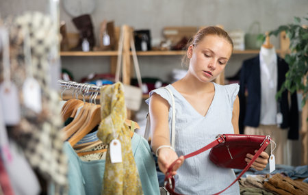 European buyer chooses a handbag in a store