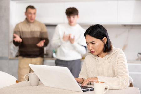 Guy and man quarrel with young woman with laptopの写真素材