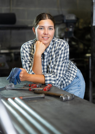 Young woman posing in metallurgical workshopの写真素材