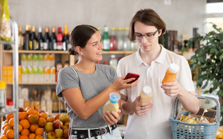 Couple scans packages of sauceの写真素材