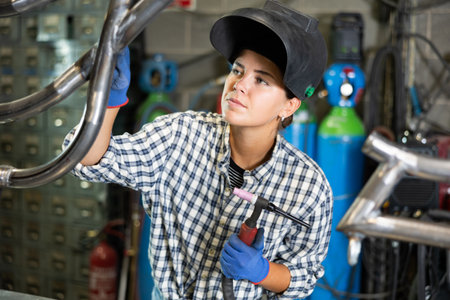 Young woman working with welding machineの写真素材