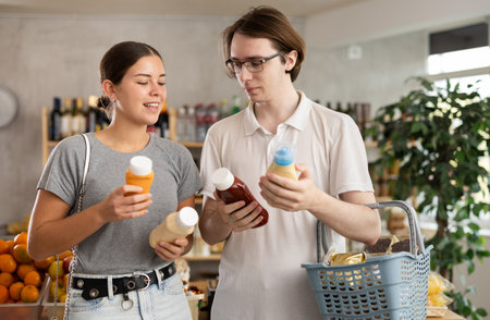 Couple young man and woman choosing saucesの写真素材