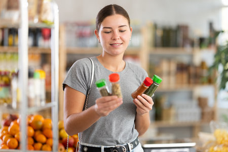 Woman chooses spices and seasoningsの写真素材