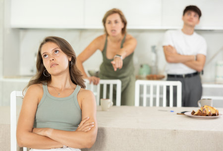 Woman and guy swear at girl. Mom and older brother scold young girl for unsuccessful studies at university. Complex intergenerational relationshipsの写真素材